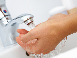 Hande Waschen unterm Wasserhahn