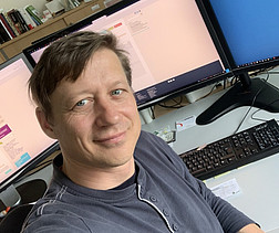 Portrait von Harald Brunner, Mitarbeiter der Parlamentsdirektion vor seinem Computer.