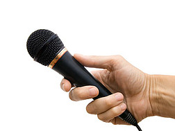 Eine Hand hält ein Mikrophon.