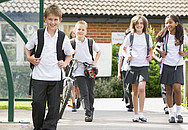 Schüler und Schülerinnen in Schuluniformen auf dem Weg zur Schule.