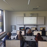 SchülerInnen sitzen in der Klasse vor den PC-Bildschirmen 