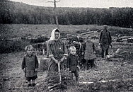 Historisches Foto von einer Frau, die mit Kindern Brennholz sammelt.