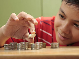 Eine Junge ordnet Münzen in Stapeln an.
