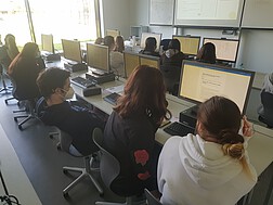 SchülerInnen sitzen während des Chats vor dem Computer 