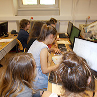 Schüler und Schülerinnen von hinten vor ihrem Computer