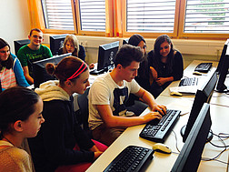 SchülerInnen sitzen vor einem Computerbildschirm und chatten 