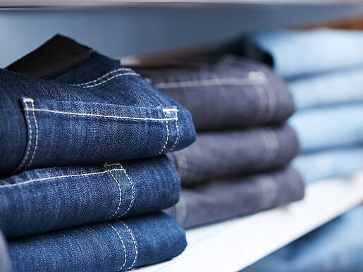 Jeans auf einem Regal c kadmy Clipdealer Mehrere Stapel mit Jeans im Regal