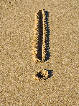 Ein Ausrufezeichen in Sand gemalt