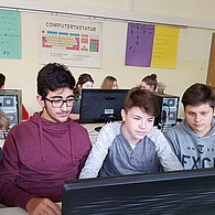 Vier Schüler vor ihrem gemeinsamen Computer.
