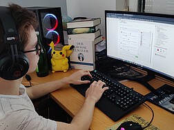 Schüler aus Pinkafeld sitzt mit Headset vor seinem Computerbildschirm