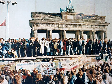 Menschen stehen auf der Berliner Mauer nach dem 9. November 1989