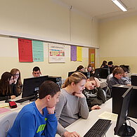 Schüler und Schülerinnen vor ihrem gemeinsamen Computern.