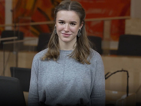 Portraitbild von Susanna Öllinger, dahinter die Sitzbänke im Redoutensaal 