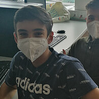 Zwei Schüler mit FFP2-Masken strecken den Daumen nach oben 