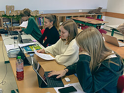 Schüler:innen sitzen im Klassenraum vor Computern
