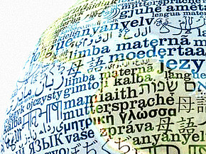 Weltkugel mit verschiedenen Sprachen beschrieben. Teaserbild Thema "Sprache(n) und Demokratie"
