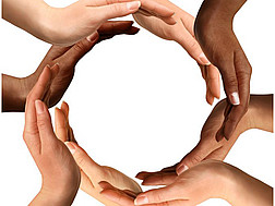 Die Hände unterschiedlicher Menschen formen einen Kreis vor einem weißen Hintergrund