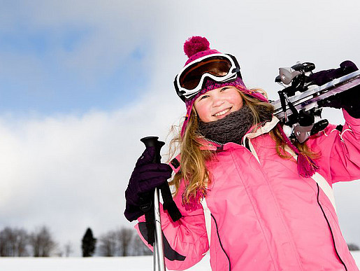 Ein Mädchen mit Skiausrüstung auf der Piste