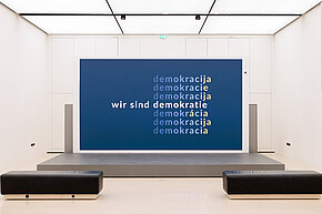 Bildschirm mit dem Wort "Demokratie" in verschiedenen Sprachen