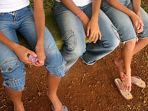 Kinder mit baumelnden Beinen