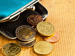 Eine geöffnete Geldbörse mit Euro- und Centmünzen