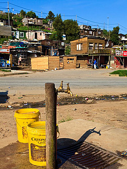 Ein Trinkwasserbrunnen neben einer Straße in Township, Südafrika
