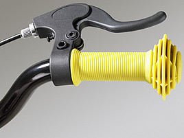 Die rechte Seite eines Fahrradlenkers mit gelber Schutzkappe und Bremse.