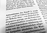 Ein aufgeschlagenes Wörterbuch mit der Definition von Antisemitismus.