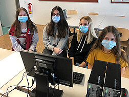 Vier Schülerinnen aus Horn sitzen beim Chat vor einem Computer