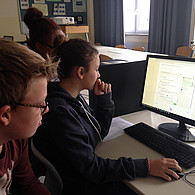 Zwei Schüler vor ihrem Computer mit Blick auf den Bildschirm.