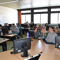 Blick ins Klassenzimmer mit Schülern und Schülerinnen an ihren Computerplätzen.