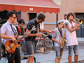 Link zu Quiz Politik und Musik; Bild: Fünf Männer musizieren auf einer Straße