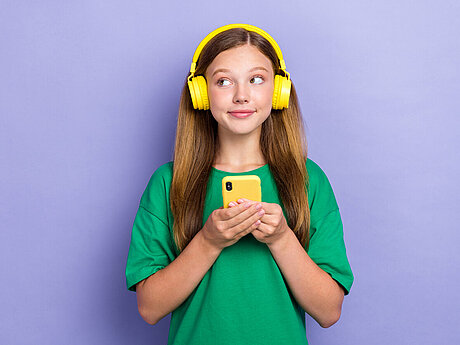 Junge Frau mit Handy und Kopfhörern