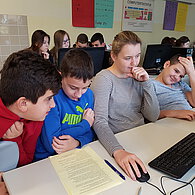 Schüler und Schülerinnen vor ihrem gemeinsamen Computern.