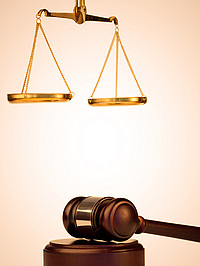 Hammer und Waage als Symbol für die Rechtssprechung vor einem hellen Hintergrund