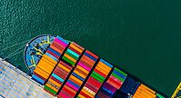 Das Bild zeigt ein Containerschiff mit voller Ladung von oben