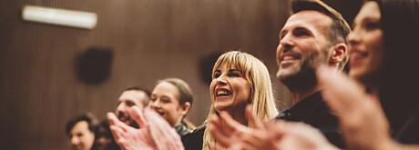 Menschen klatschen Beifall und lachen 