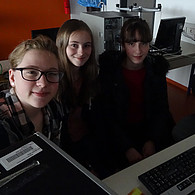 Drei Schülerinnen vor ihrem gemeinsamen Computer.