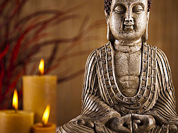 Eine Buddha-Statue mit Kerzen im Hintergrund