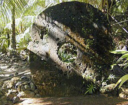 Yap Stone Money. Ein verwitterter, kreisrund behauener, etwa 1,5m großer Stein, der mitten im Urwald steht und als Zahlungsmittel verwendet wurde.