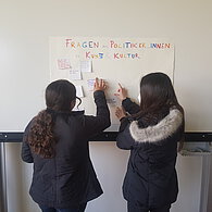 Zwei SchülerInnen kleben Post-its an die Tafel