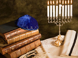 Bibeln, Gebetsschal, jüdisches Käppchen und neunarmiger Chanukkaleuchter