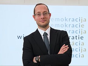 Jürgen Pirker vor Ausstellungsplakat