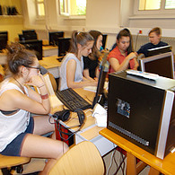 Schüler und Schülerinnen seitlich vor ihren Computern im Klassenzimmer