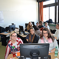 Blick ins Klassenzimmer mit Schülern und Schülerinnen an ihren Computerplätzen.