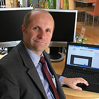 Portrait von Bundesrat Gerald Zelina vor seinem Laptop.