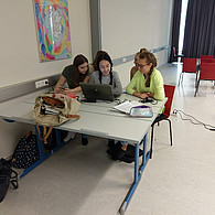 Drei Schülerinnen vor ihrem gemeinsamen Laptop im Klassenzimmer
