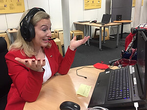 Eine Frau sitzt beim Workshop der Lehrlingsforums vor einem Computer, die Hände in einer fragenden Handstellung nach oben hin gebeugt