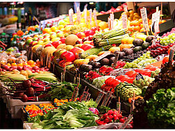 Ein großer Marktstand mit Kisten von Obst und Gemüse