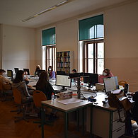 SchülerInnen sitzen in zwei Reihen vor den Computern 